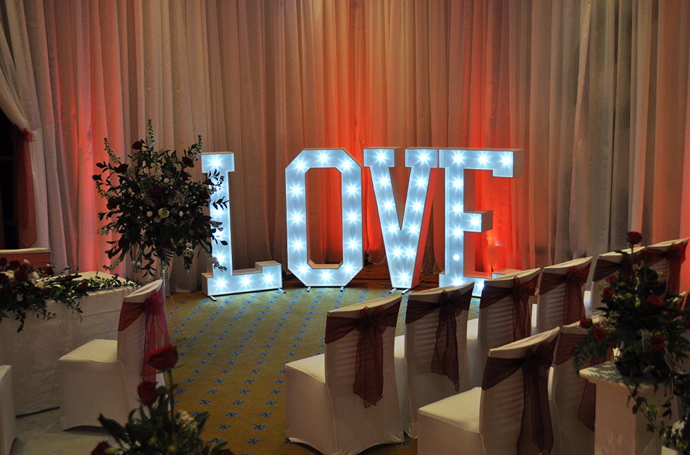 1.45 m tall white fairground bulb LOVE wording for a wedding ceremony at Bowood