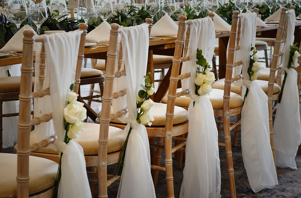 Chivari chairs with Ivory White Chiffon chair sash drops at De Vere Cotswold waterpark Hotel with floral flowerhead addition