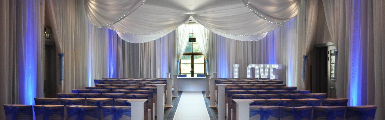 Wedding at Bowood Golf Club and Hotel with ceiling and wall drapes with blue uplighting
