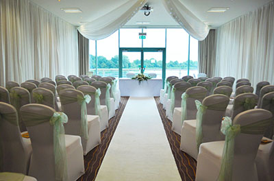 Mint green themed ceremony room, with room and ceiling drapes, at the Cotswold Water Park Hotel